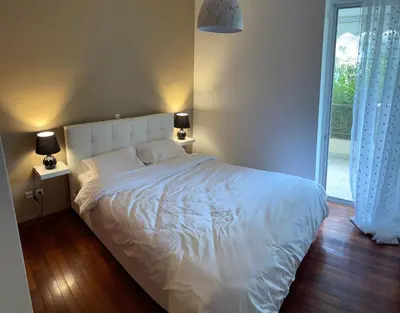 a bedroom with a white bed with two lamps and a window at Marble Athens Riviera in Athens