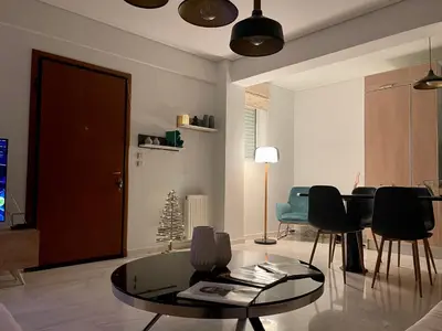 a living room with a glass table and chairs at Marble Athens Riviera in Athens