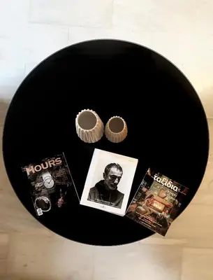 a black plate with a cupcake and magazines on it at Marble Athens Riviera in Athens