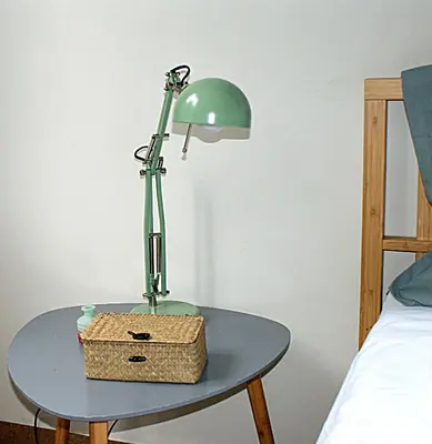 a green lamp on a table next to a bed at Central studio in Monastiraki in Athens