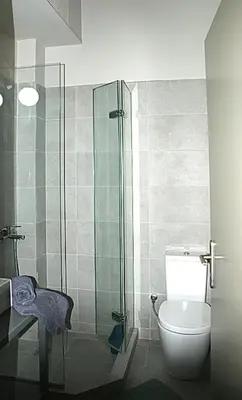 a bathroom with a toilet and a glass shower at Central studio in Monastiraki in Athens