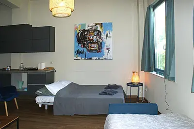 a room with two beds and a painting on the wall at Central studio in Monastiraki in Athens
