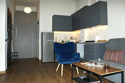 a living room with a blue chair and a table at Central studio in Monastiraki in Athens
