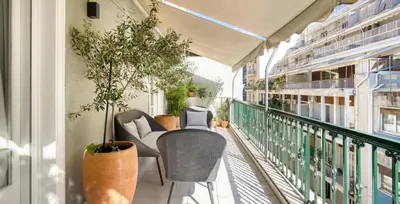 a balcony with chairs and plants on a building at Alopekis in Athens