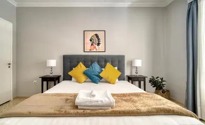 a bedroom with a large bed with yellow and blue pillows at Alopekis in Athens
