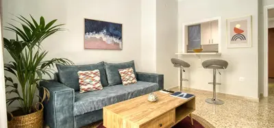 a living room with a blue couch and a wooden coffee table at Alopekis in Athens