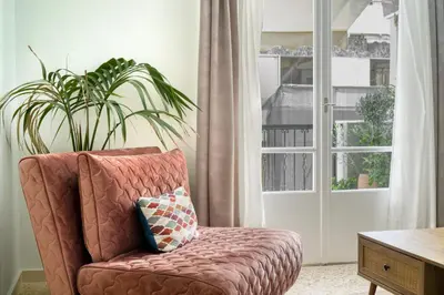 a living room with a chair and a plant at Alopekis in Athens