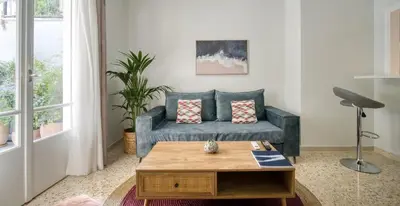 a living room with a blue couch and a coffee table at Alopekis in Athens