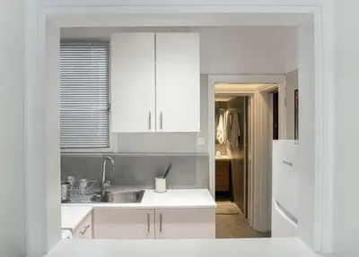 a white kitchen with a sink and a refrigerator at Alopekis in Athens