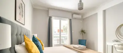 a bedroom with a bed with yellow and blue pillows at Alopekis in Athens