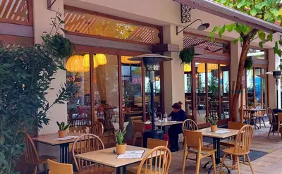 a restaurant with tables and chairs and people sitting at them at Irene's Beauty in Koukaki in Athens