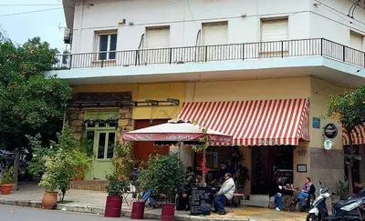 a restaurant with an umbrella in front of a building at Irene's Beauty in Koukaki in Athens