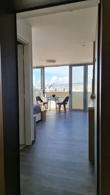 a living room with a view of a table and chairs at Xenophon Suite at National Opera SNFCC Park in Athens