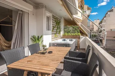 a wooden table and chairs on a balcony at Athenian home in Athens