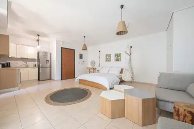 a living room with a bed and a kitchen at Athenian home in Athens