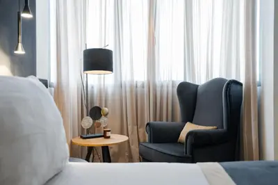 a room with a bed and a chair and a lamp at Athenian Riviera Luxurious Residence in Athens