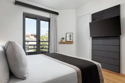 a bedroom with a white bed and a large window at Athenian Riviera Luxurious Residence in Athens