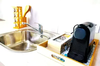 a kitchen counter with a sink and a kitchen appliance at Santo House in Athens