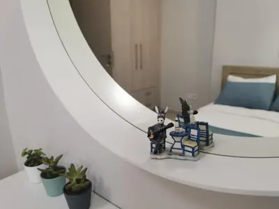 a table with two figurines on it next to a mirror at Santo House in Athens