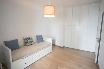 a white room with a couch with blue pillows at A.P Athens in Athens