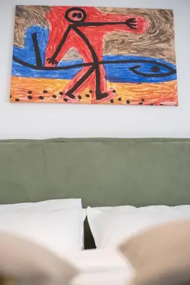 a painting of a man on a surfboard above a bed at A.P Athens in Athens