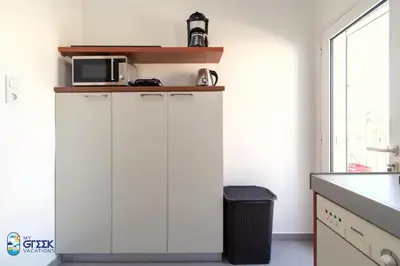 a white cabinet in a kitchen with a microwave at The Spiritual Athens Apartment in Athens