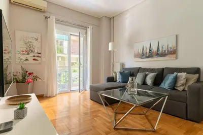 a living room with a couch and a glass table at Modern full apt near acropolis/vaccinatedHosts in Athens