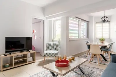 a living room with a television and a dining room at Brand New Bright modern 6bdr apt-1min to Acropolis in Athens