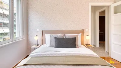 a bedroom with a large bed with two lamps at Contemporary 2-BDR APT near Kalimarmaro & Alsos Park! in Athens