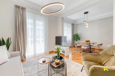 a living room with a couch and a table at Contemporary 2-BDR APT near Kalimarmaro & Alsos Park! in Athens