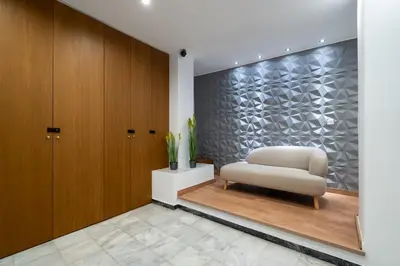 a living room with a chair and a wall at Strefi Hill Suites in Athens