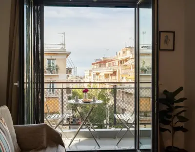 a balcony with a table and a view of a city at Strefi Hill Suites in Athens