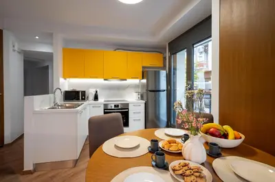 a kitchen with a table with a bowl of fruit on it at Strefi Hill Suites in Athens