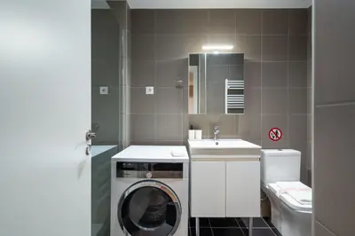 a bathroom with a washing machine and a sink at Strefi Hill Suites in Athens