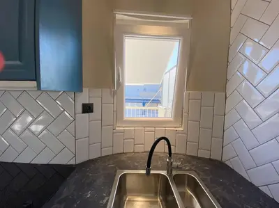 a kitchen with a sink and a window at Athens Skylight Condo in Athens