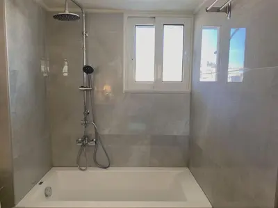 a bathroom with a shower with a bath tub at Athens Skylight Condo in Athens