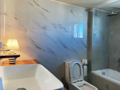 a bathroom with a white tub and a toilet and a sink at Athens Skylight Condo in Athens