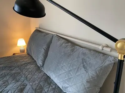 a bedroom with a bed with a black lamp at Athens Skylight Condo in Athens