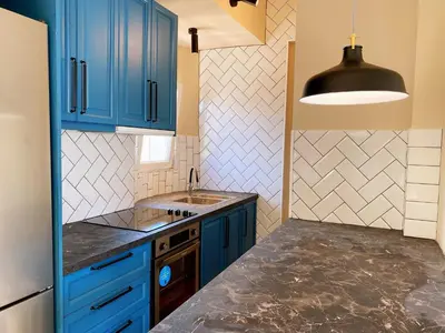 a kitchen with blue cabinets and a sink at Athens Skylight Condo in Athens