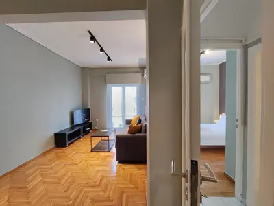 a living room with a couch and a television at Veno Apartments Goudi in Athens