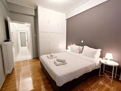 a bedroom with a large white bed in a room at Veno Apartments Goudi in Athens