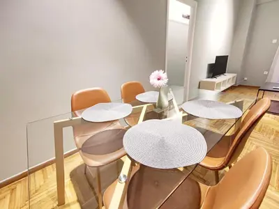 a dining room with a glass table and chairs at Veno Apartments Goudi in Athens