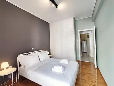 a bedroom with a white bed with two towels on it at Veno Apartments Goudi in Athens