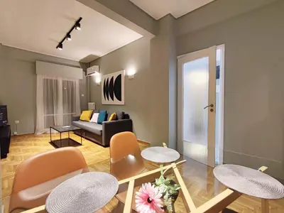 a living room with a couch and tables and chairs at Veno Apartments Goudi in Athens