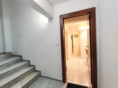a hallway with stairs and a door leading into a room at Avli apartment in Athens