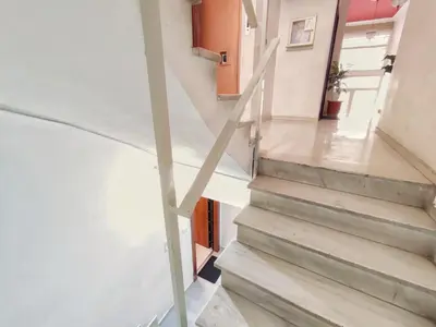 a staircase in a house with concrete floors and white walls at Avli apartment in Athens
