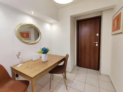 a dining room with a wooden table and a mirror at Avli apartment in Athens