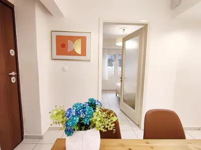 a vase with flowers on a table in a hallway at Avli apartment in Athens