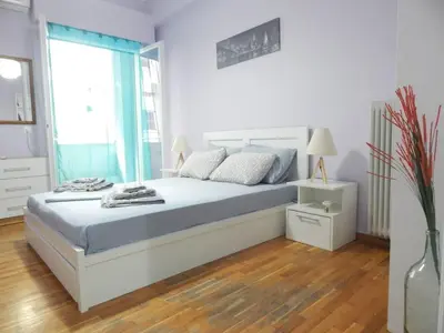 a bedroom with a bed with blue sheets and a window at 2 Bed Flat - Sleeps 4 - Pets - Parking - Wifi in Athens