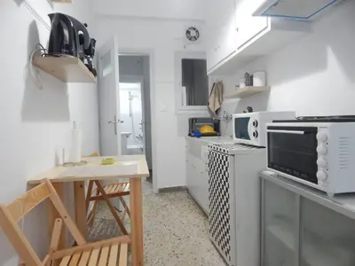a small white kitchen with a table and a stove at 2 Bed Flat - Sleeps 4 - Pets - Parking - Wifi in Athens